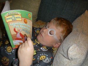 Kevin reading with homemade glasses, caught in the act of reading, pragmatic mom