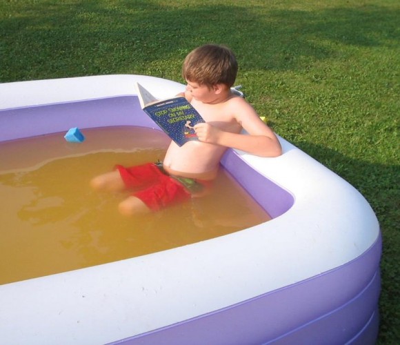 boy reading in pool