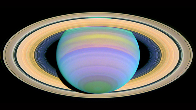 Saturn is seen here in ultraviolet light. Particles in Saturn's atmosphere reflect different wavelengths of light in discrete ways, causing some bands of gas in the atmosphere to stand out vividly in an image, while other areas will be very dark or dull. 