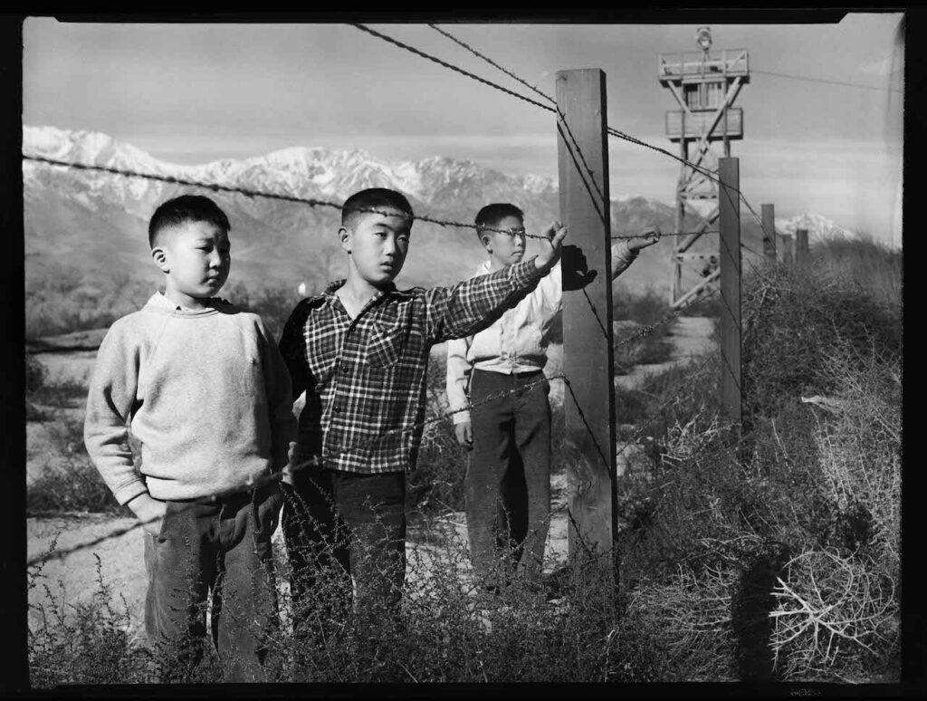 “Three Boys Behind Barbed Wire”, taken by Toyo Miyatake in 1944.